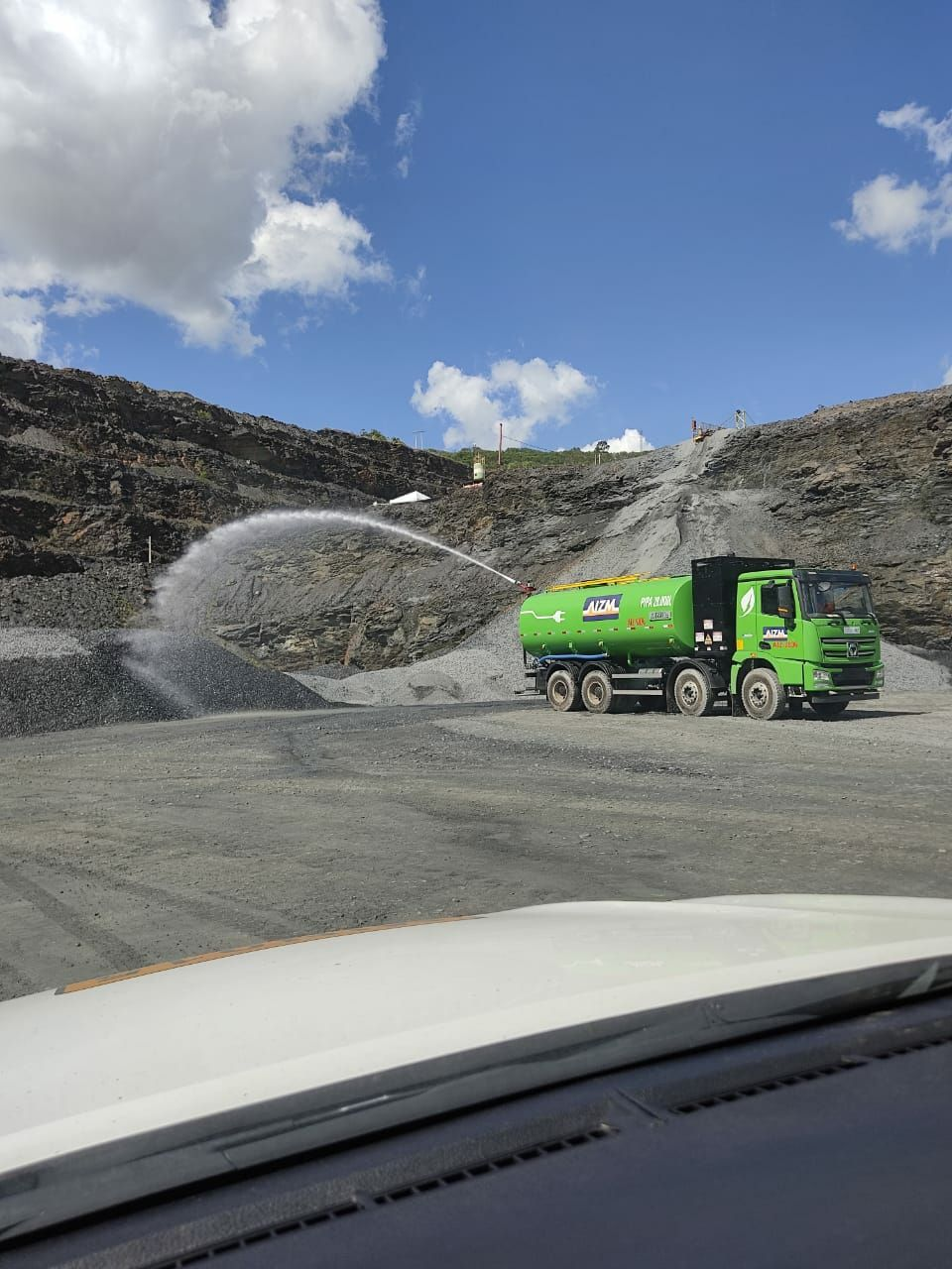 Caminhão elétrico com tanque-pipa aspergindo água dentro da operação de mineração da Kinross